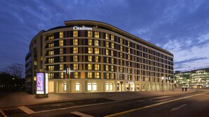 A modern hotel with a curved facade, multiple floors, and illuminated windows. - Citadines City Centre Frankfurt (Frankfurt)