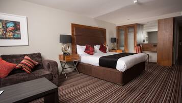 Una habitación de hotel con una cama grande, un sofá, un escritorio y un espejo.