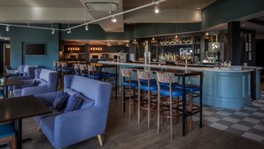 Un área de bar moderna con asientos y una barra.