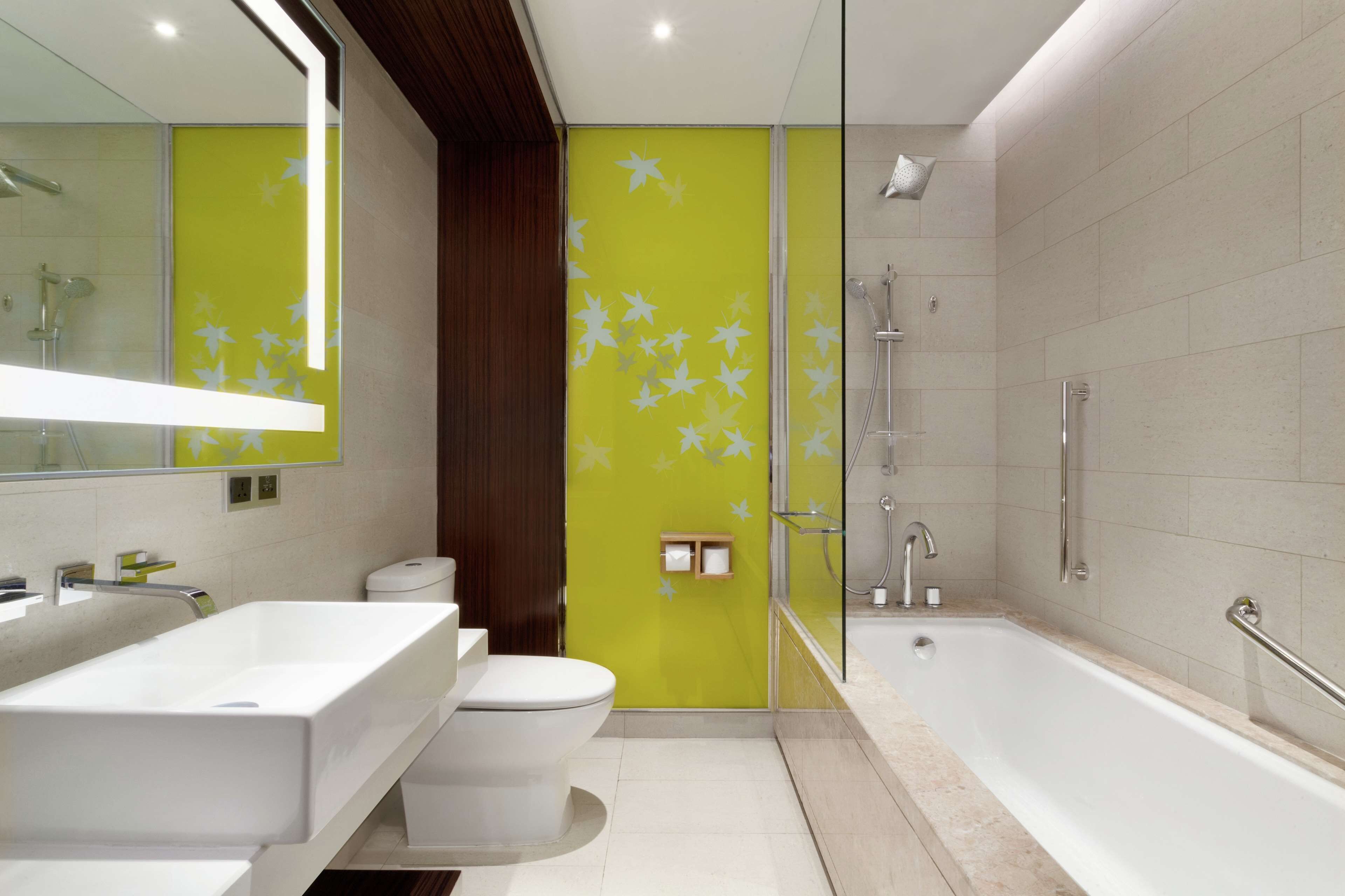 A modern bathroom with a white sink, toilet, and bathtub.