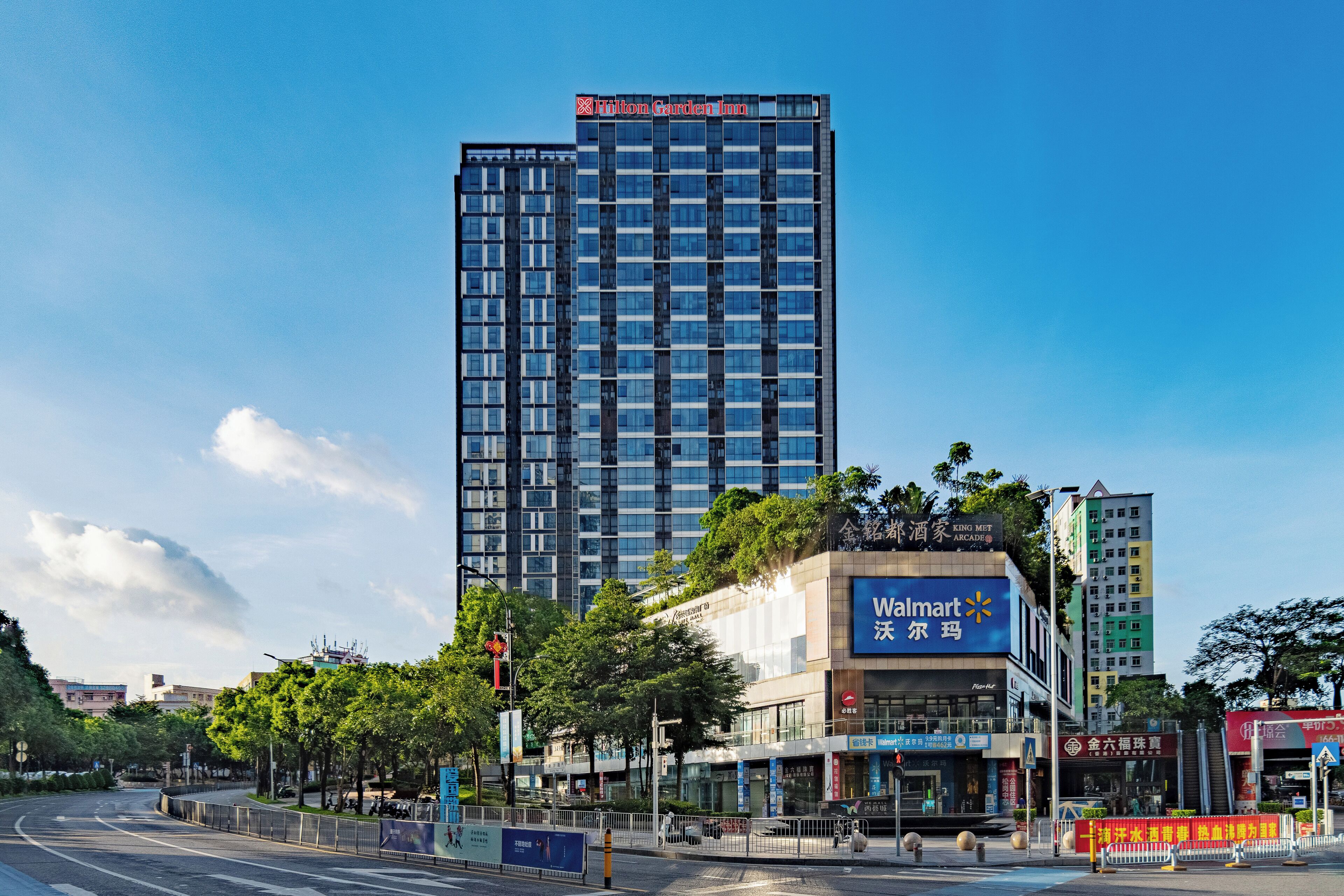 A high-rise building with a visible sign for 'Walmart' and 'King Met Arcade' on its facade.