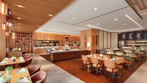 Un restaurante moderno con paneles de madera, una barra central y varias mesas con sillas.