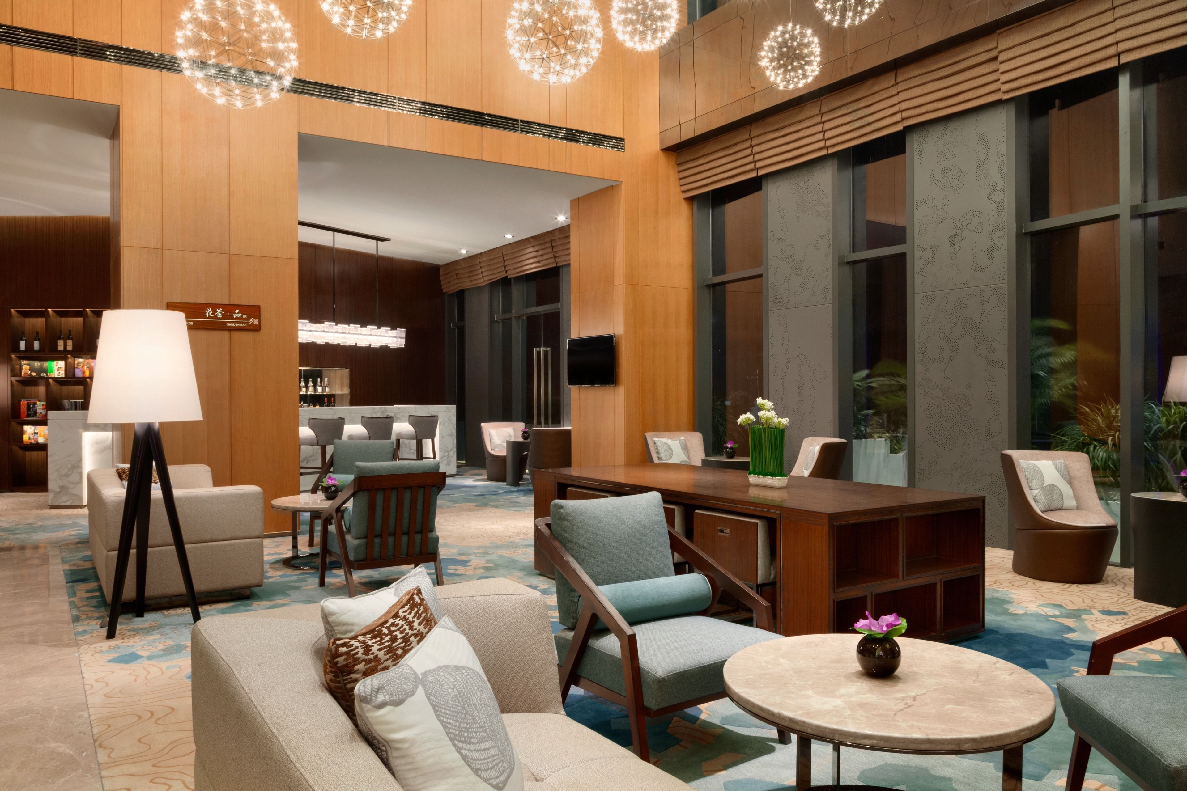A modern lobby with a seating area, a bar, and a reception desk.