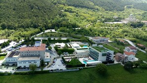 An aerial view of a hotel complex with multiple buildings, a swimming pool, and a lush green landscape. - La Fonte dell'Astore (Castelpetroso)