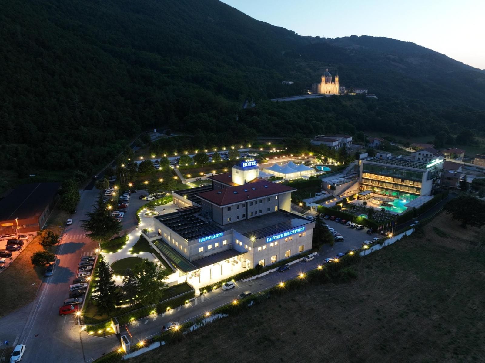 Un complexe hôtelier comprenant plusieurs bâtiments, une piscine et offrant une vue sur les montagnes.