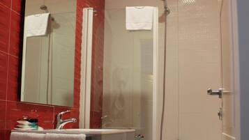 Une salle de bain avec une baignoire, un lavabo, un miroir et une douche.