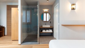 A modern bathroom with a glass shower enclosure, a round mirror, and a wooden vanity. - A3Passi Agriturismo tra gli Ulivi (Ancona)