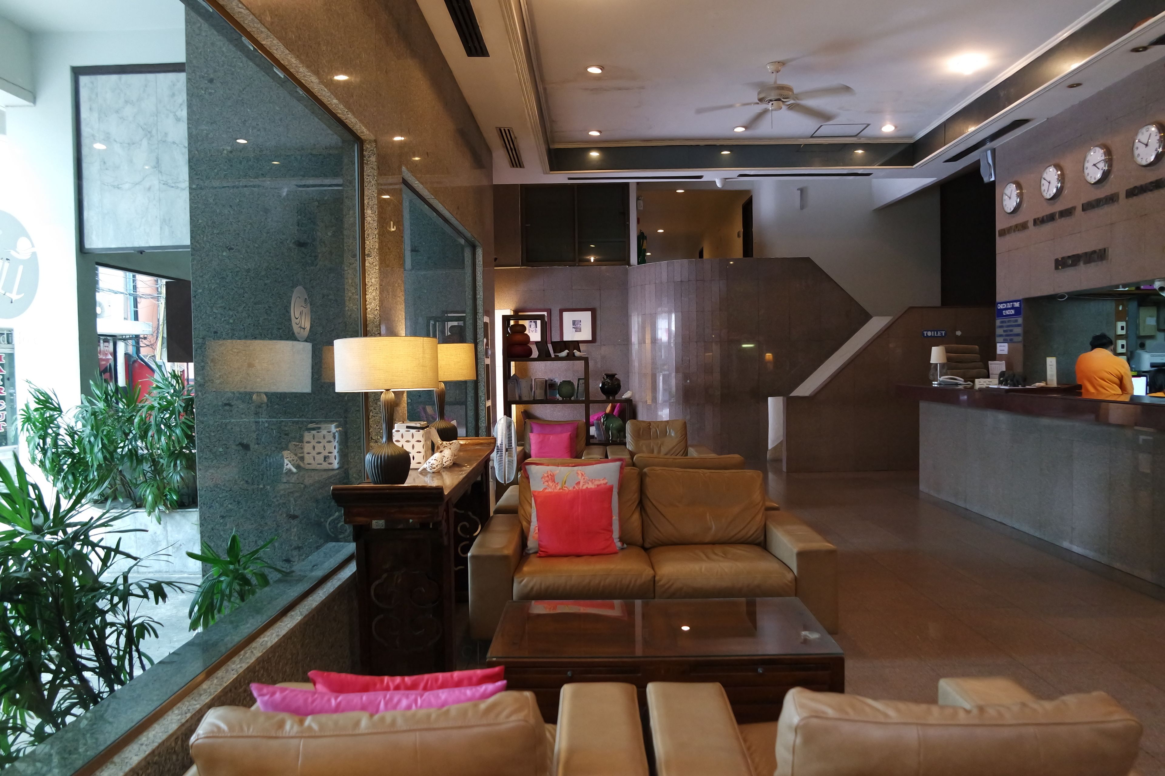 A modern lobby with leather sofas, a coffee table, and a reception desk.