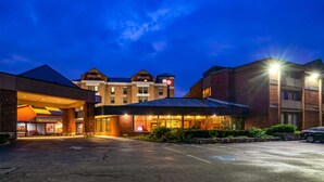 Un hotel con fachada de ladrillo, varios pisos y una entrada bien iluminada.