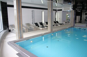 Una piscina techada, sillones reclinables de piscina