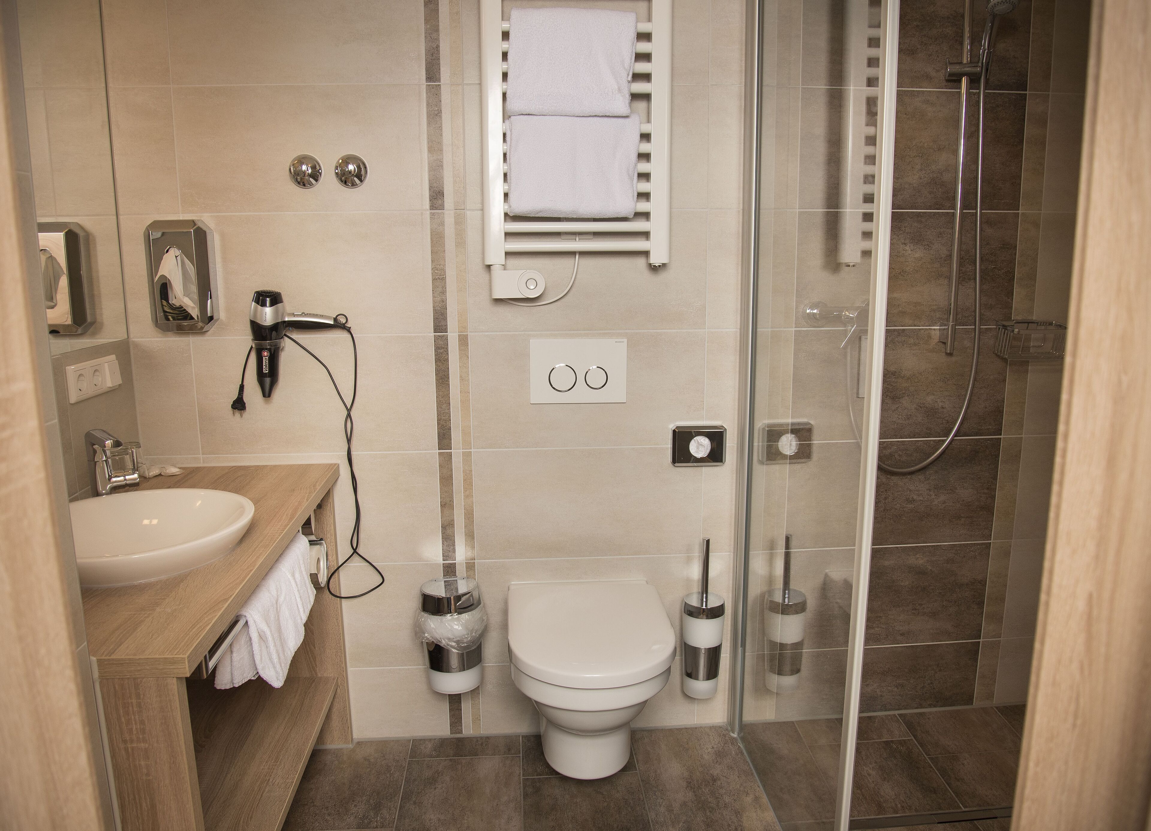 Un baño moderno con inodoro, lavamanos y zona de ducha.