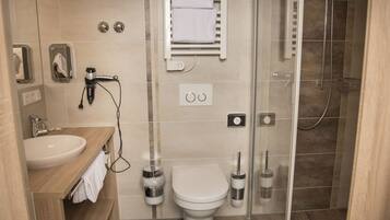 Un baño moderno con inodoro, lavamanos y zona de ducha.