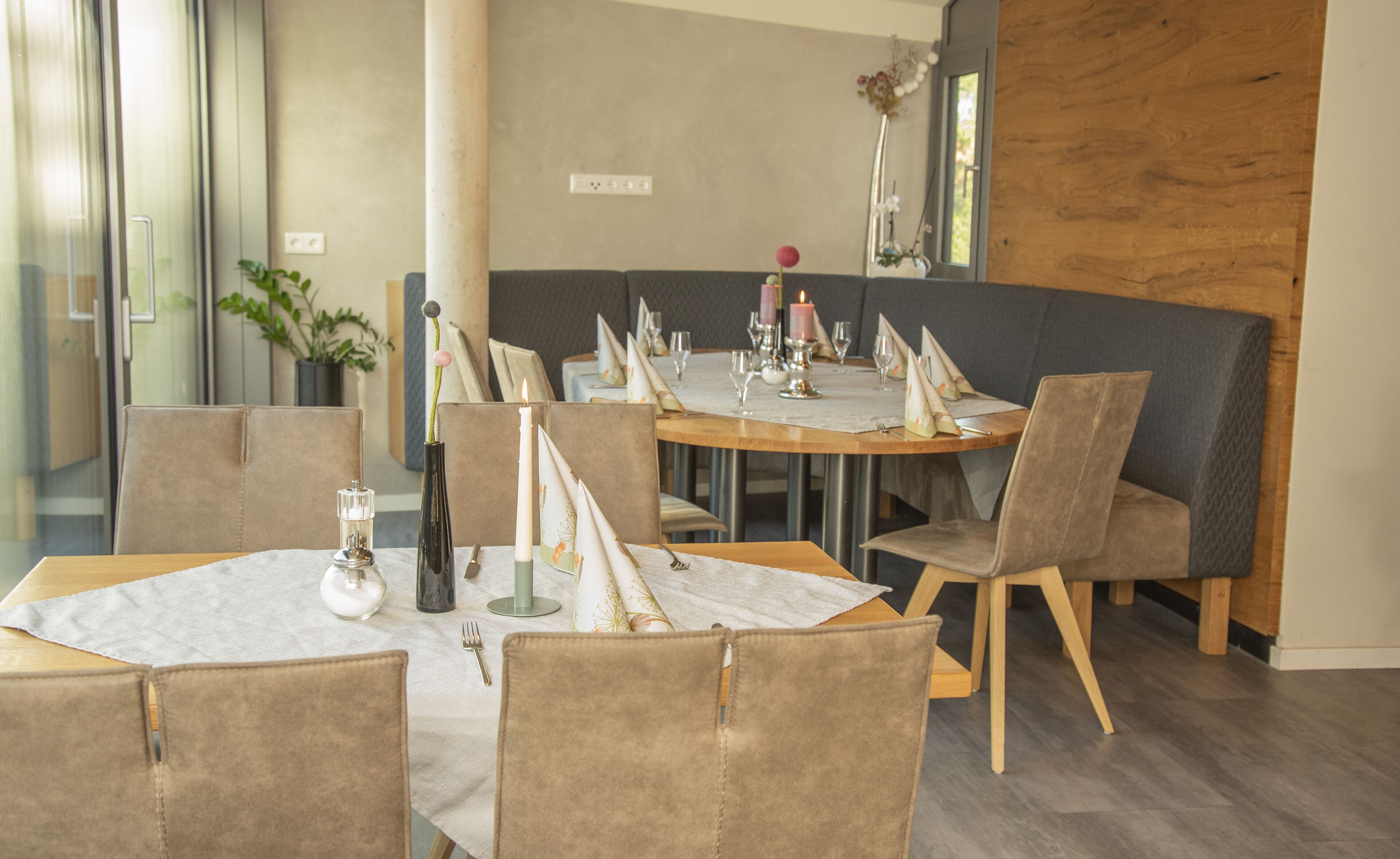 Un área de comedor moderna con mesas redondas, sillas acolchadas y una decoración minimalista.