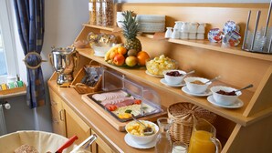 A breakfast buffet with various fruits, bread, and dairy products.