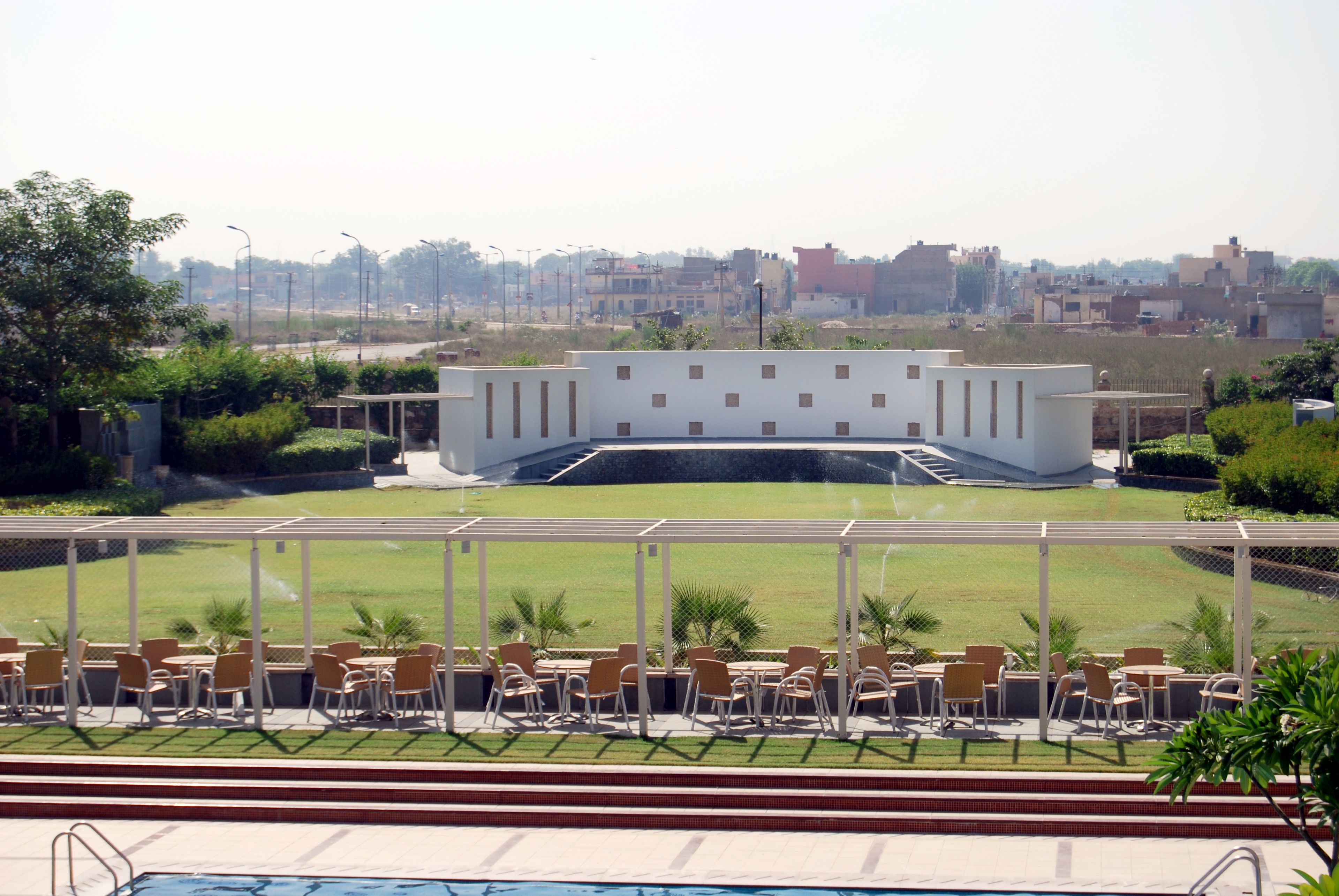 A poolside area with outdoor seating and a view of a building in the background.