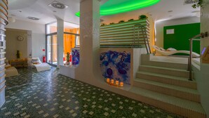A modern spa area with a tiled floor, a staircase, and a wall with a blue abstract painting.