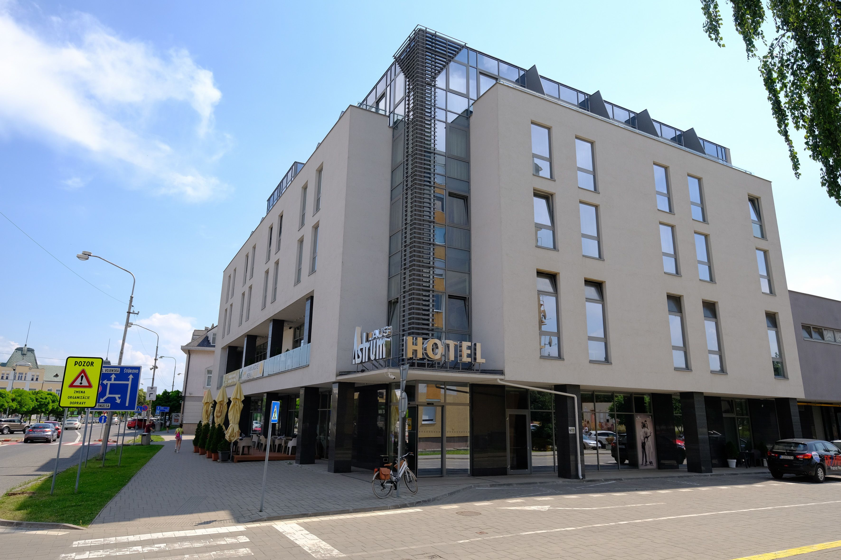 Un hôtel moderne doté d’un escalier imposant, de grandes fenêtres et d’une enseigne indiquant qu’il s’agit d’un hôtel.
