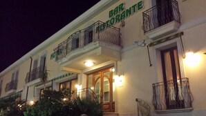 A building with a bar and restaurant sign, balconies with metal railings, and a wooden door. - Hotel Ristorante Stella 2000 (Olbia)