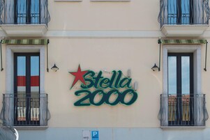 A hotel sign with balconies and windows.