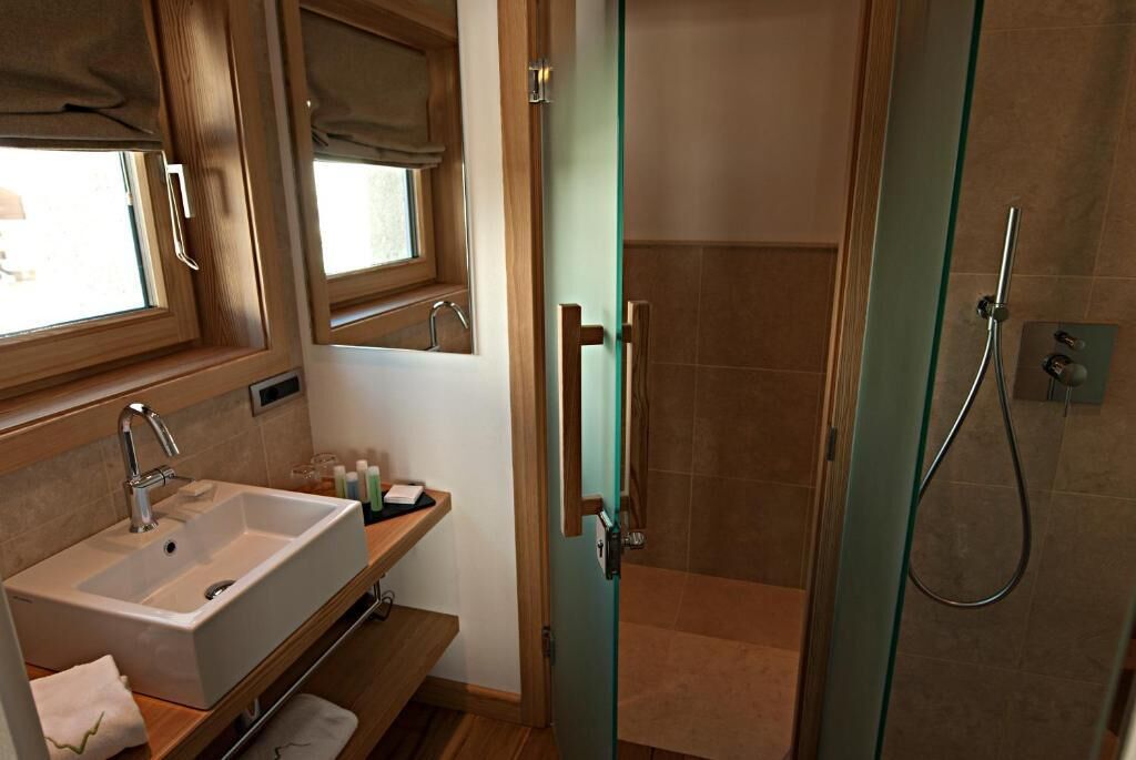 Un baño con lavamanos, espejo y ducha.