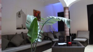 Una sala de estar moderna con un sofá, una mesa de centro y una planta grande.