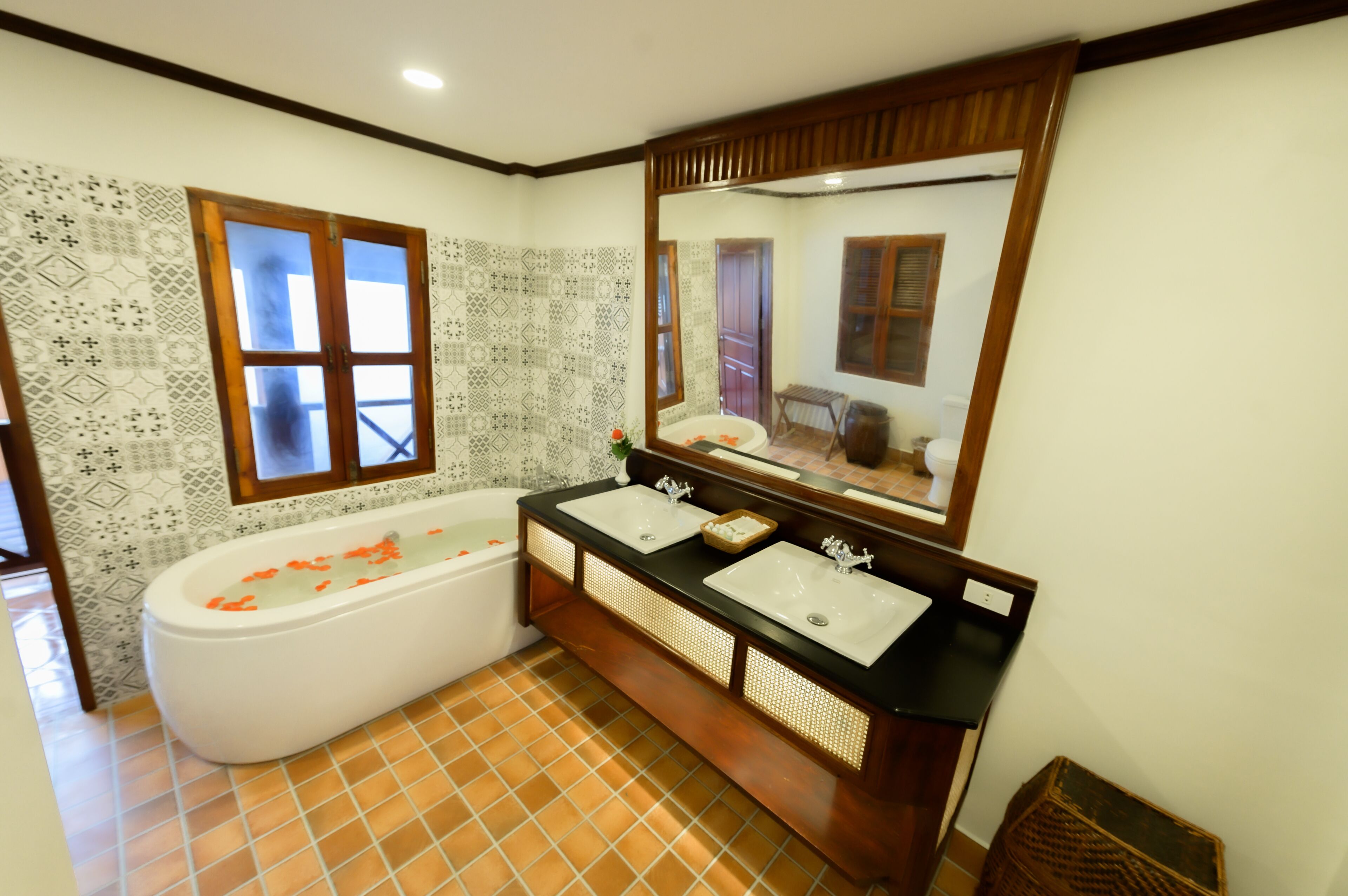 A bathroom with a freestanding bathtub, two sinks, and a large mirror.