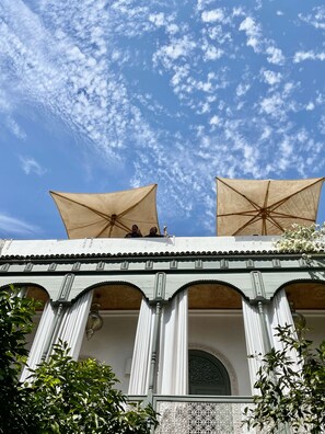 Ein Gebäude mit Balkon, Säulen und einem verzierten Bogen.