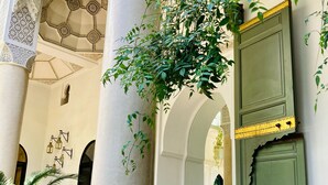 An interior with a green door, a sofa, and a birdcage. - Riad Rafaele & Spa (Marrakech)