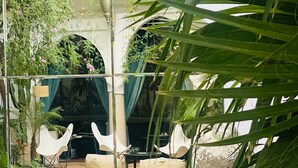 An indoor swimming pool with clear water, surrounded by white chairs and a small table, with plants and a decorative lamp in the background. - Riad Rafaele & Spa (Marrakech)