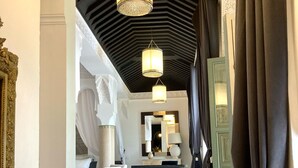 A hallway with a staircase, a dining area, and a room with a bed. - Riad Rafaele & Spa (Marrakech)