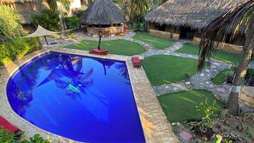 Relax by the serene pool surrounded by lush landscaping and shaded seating areas.