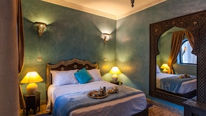 Un dormitorio con una cama grande, dos lámparas de noche, un espejo y una bandeja con té y azúcar sobre la cama.