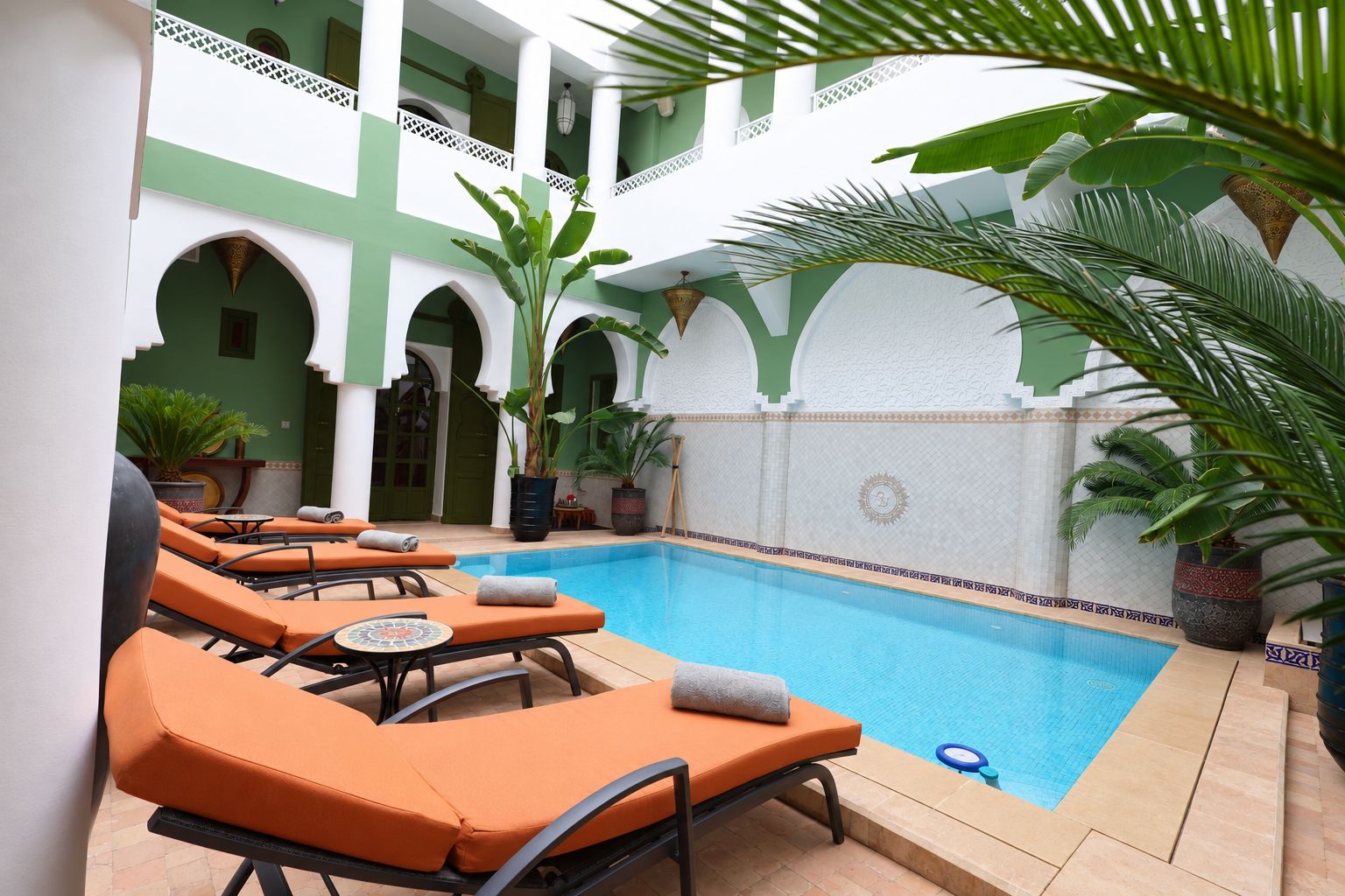 Un espace aménagé au bord de la piscine, avec des chaises longues et une piscine.