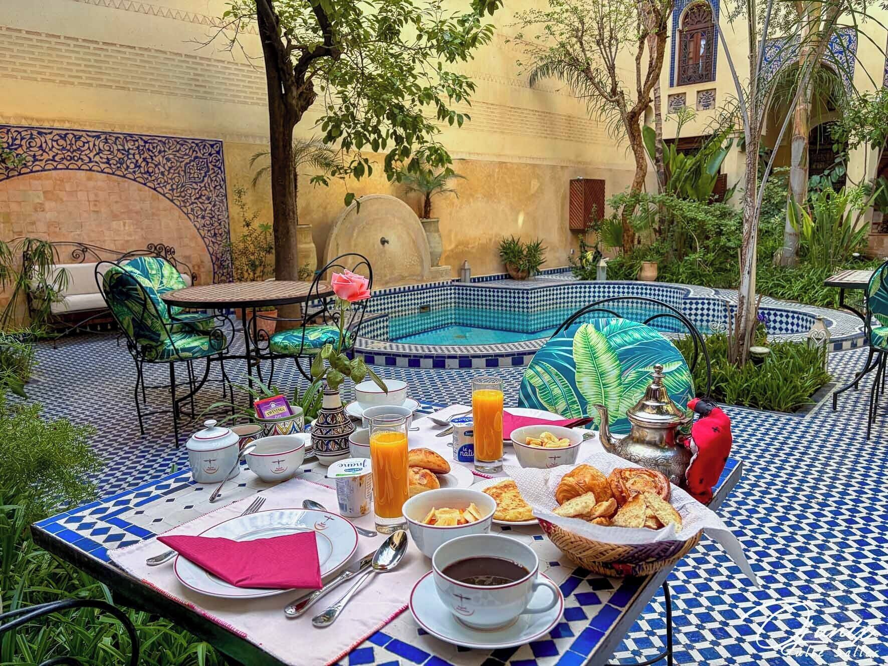 A dining area with a pool, outdoor seating, and a tiled floor.