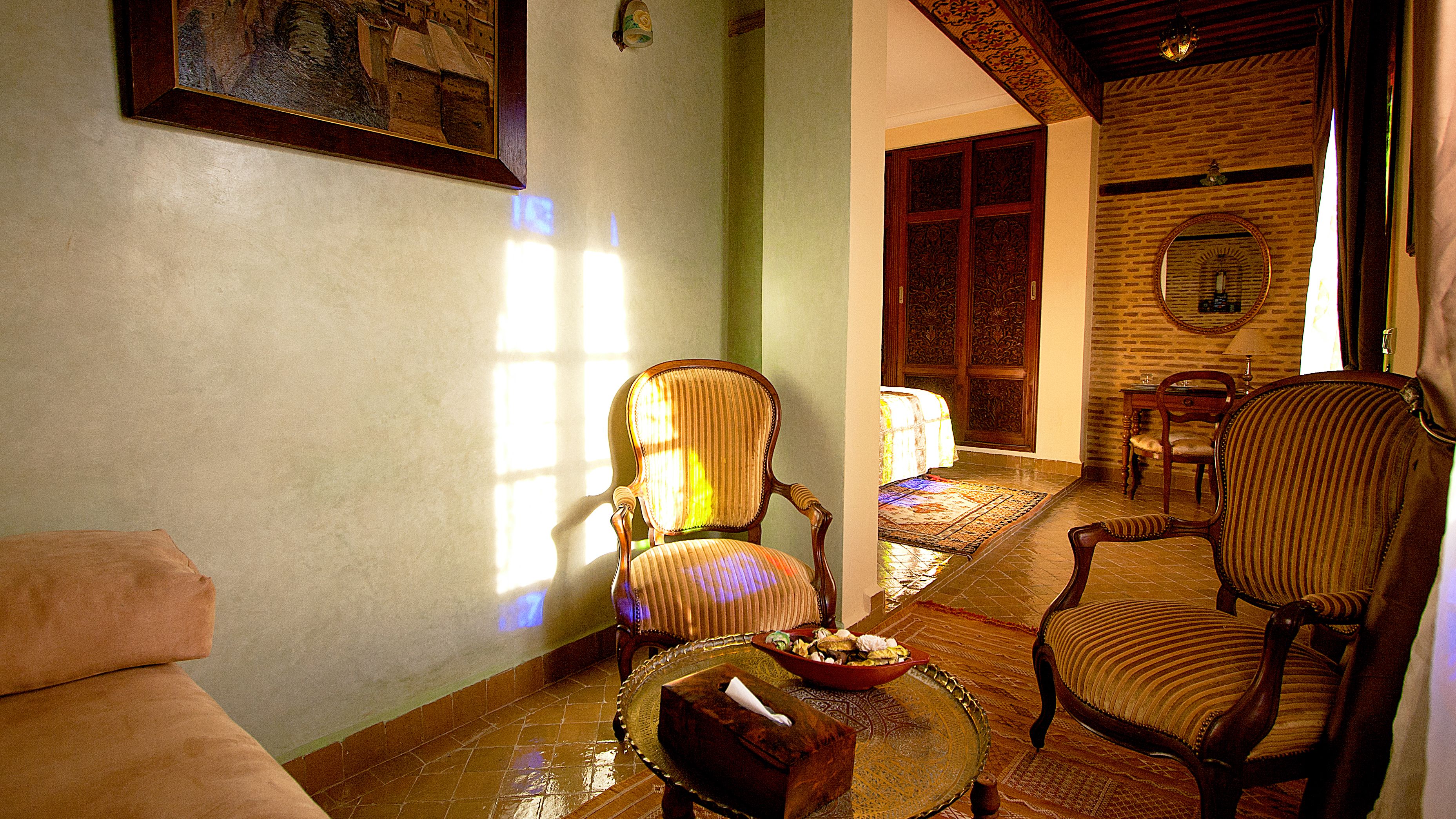 A cozy living room with a sofa, two armchairs, a coffee table, and a dining table with chairs.