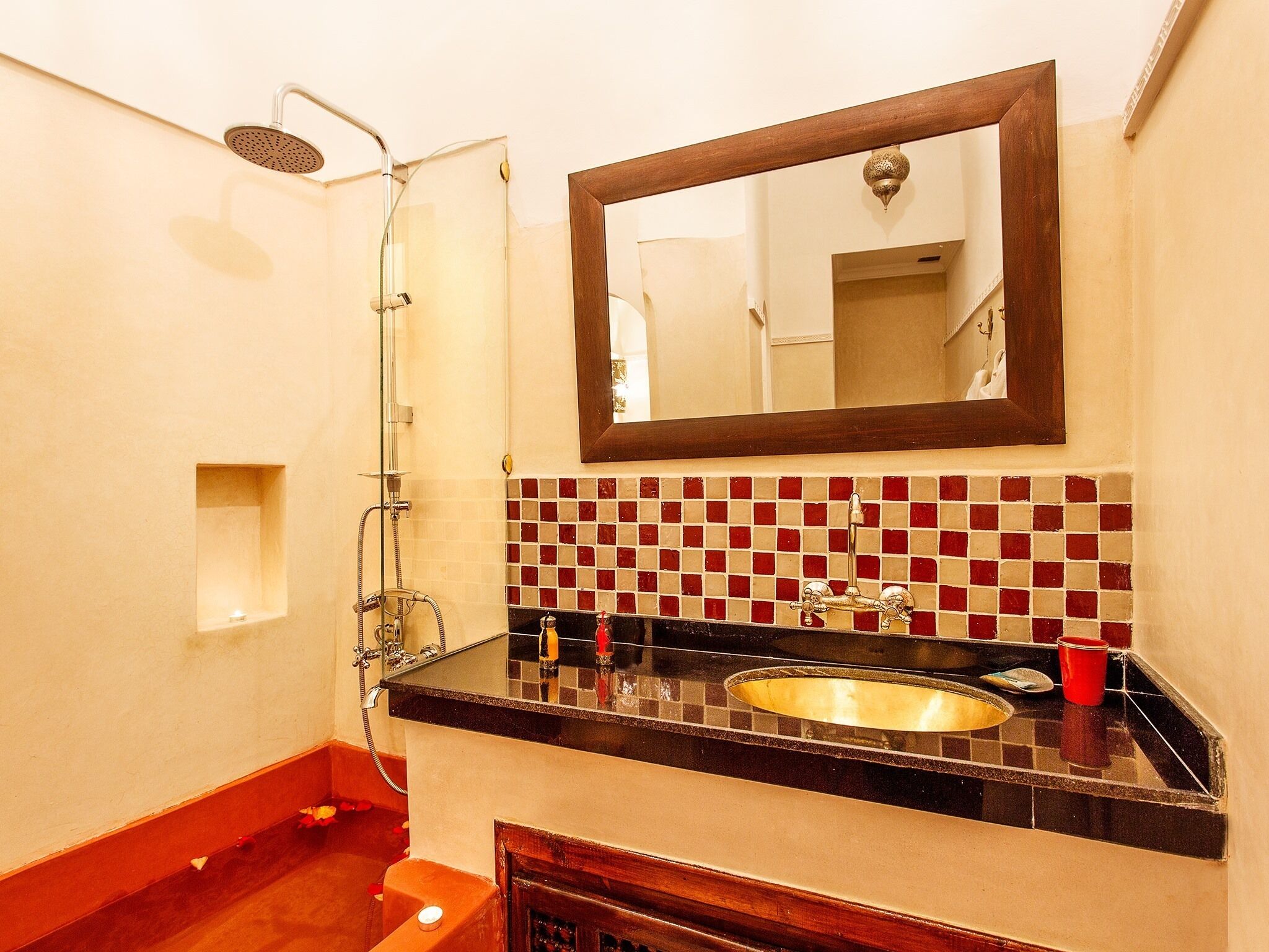 A bathroom with a shower, sink, and mirror.