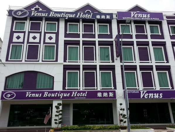 A building with the signage 'Venus Boutique Hotel' and 'West End Grill, Mussels, Pizza'.