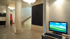 Un hall d’entrée moderne avec un grand écran, un clavier et une souris sur un bureau.