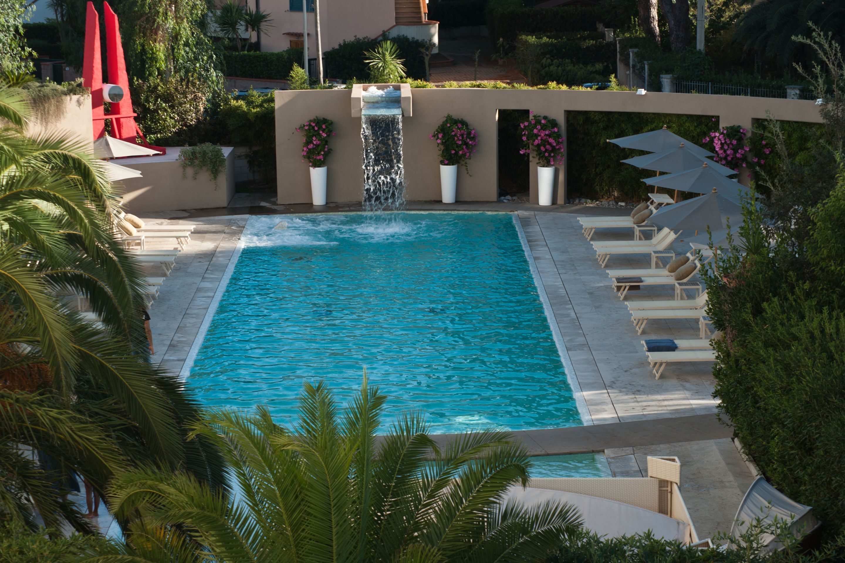 Een seizoensgebonden buitenzwembad en een zwembad met een waterval
