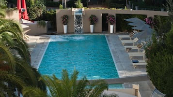 Sesongbasert utendørsbasseng, et basseng med foss og bassengparasoller