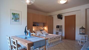 A bedroom with a bed, bedside table, lamp, and a small table with chairs.