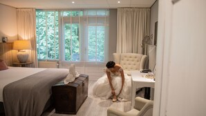 Un dormitorio con cama, cómoda, silla y ventana con cortinas.
