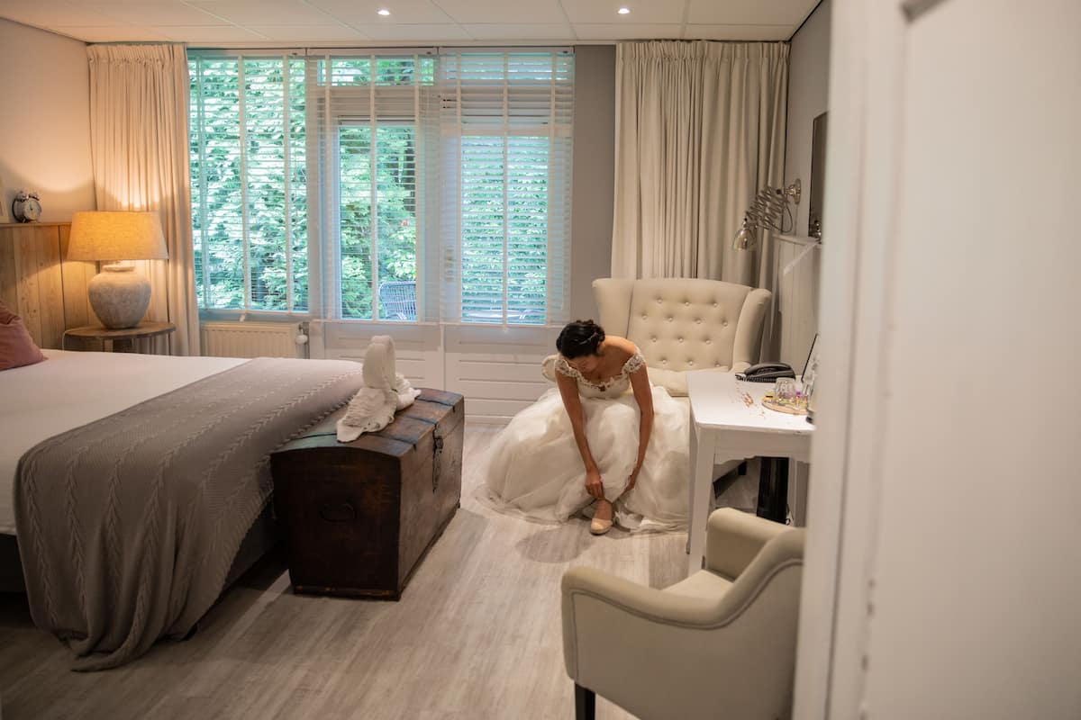 A bedroom with a bed, a dresser, a chair, and a window with curtains.