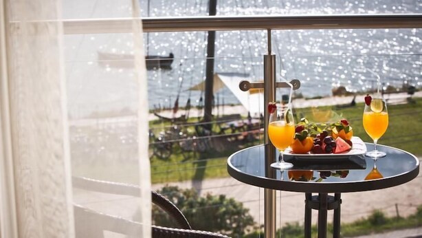 A table with drinks and fruit on a balcony with a view of boats and greenery. - Hotel 77 Restauracja Spa (Wladyslawowo)
