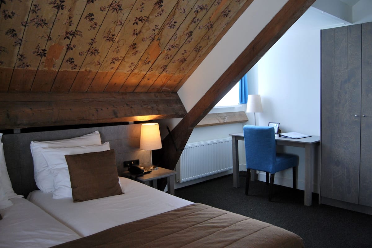 Une chambre à coucher avec un lit, un bureau et une chaise.