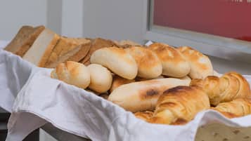A variety of breads displayed on a table with a white cloth.