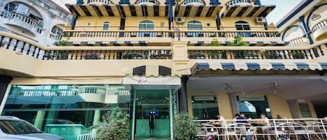 Un hôtel à plusieurs étages doté de balcons, d’un espace repas et d’une réception.
