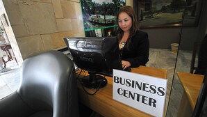 A business center with a computer monitor, a sign reading "BUSINESS CENTER", and a poster on the wall. - Elegant Circle Inn (Cebu City)