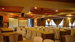 A conference room with rows of tables and chairs, a whiteboard, and a projector screen. - Elegant Circle Inn (Cebu City)