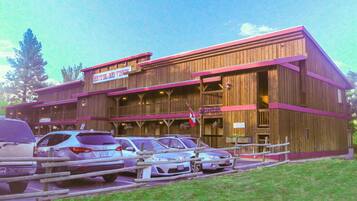 A wooden building with a sign reading "Hotel Rio Vista." There are cars parked in front.